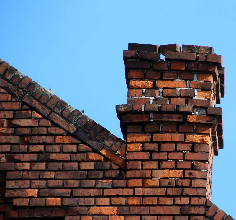 Damaged chimney on an Frisco home showing cracks and missing mortar